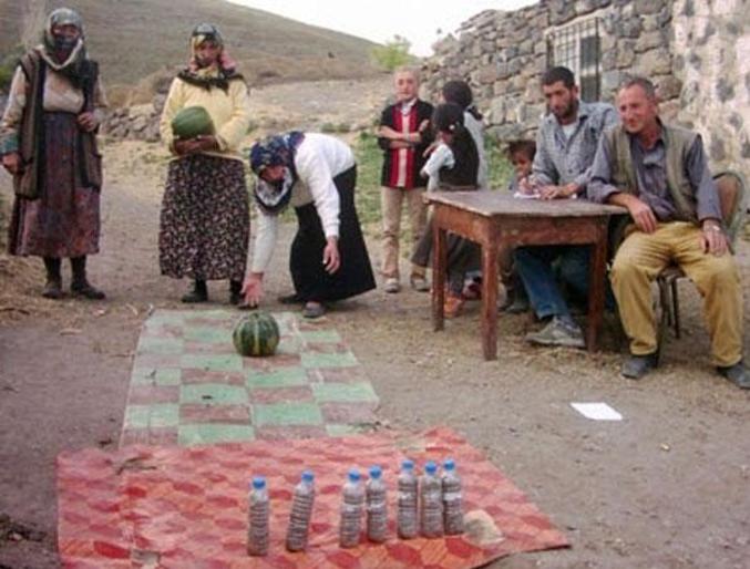 Un bowling avec des bouteilles et une pastèque.