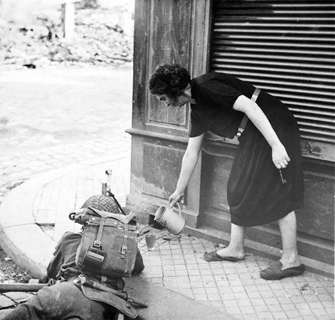 Une femme française apporte une tasse de thé à un soldat britannique. France, 1944.