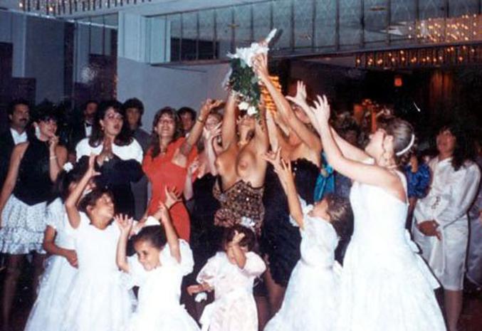Une femme tient absolument à attraper le bouquet de la mariée.