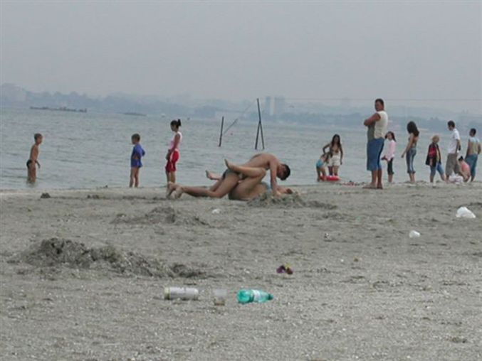 un couple qui fait l'amour sur la plage devant les touristes