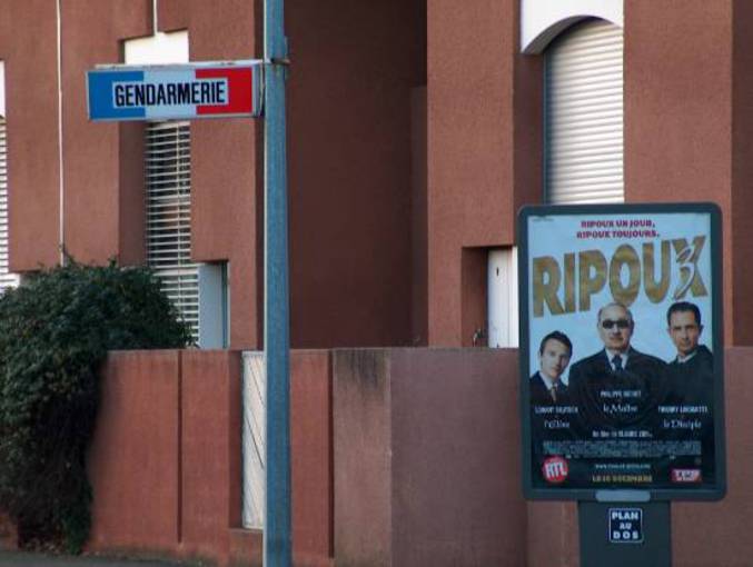 Une affiche du film "Ripoux" à coté d'une gendarmerie.
