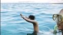 Un homme aux cheveux pointus sur le point de plonger dans l'eau