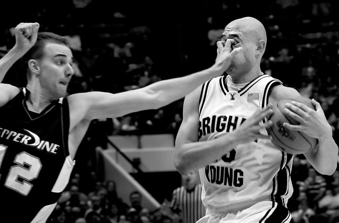 Un joueur de basket effectue un contact assez violent.