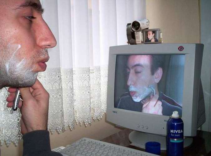 Un homme se rase via son écran.