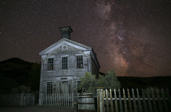 Bannack State Park est une ville fantôme dans le Beaverhead County, le plus grand county du Montana (Etats Unis). Elle permet de voir à quoi ressemblaient les villes de la Ruée vers l'Or mais elle est aussi le lieu de ciels nocturnes majestueux grâce à l'absence de pollution lumineuse.

Pour réaliser cette photo, Tyler Metcalfe a tout simplement placé son appareil sur un trépied, a fait sa mise au point à l'infini, puis réglé son appareil sur exposition longue (plusieurs secondes ou plusieurs minutes) avec une ouverture entre 2.9 et 5.6, le tout sur un grand ISO. Aucune retouche n'a été réalisée.