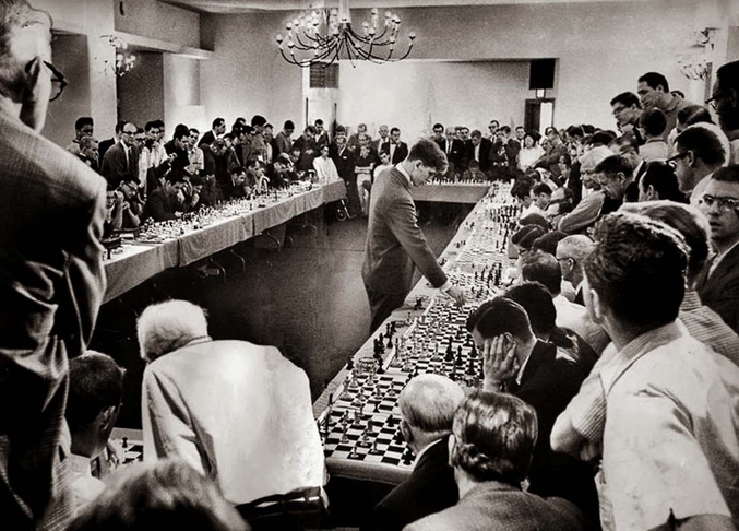 Grand maître d'échecs américain, Bobby Fischer a 21 ans lorsqu'il défie dans son hôtel à Hollywood 50 joueurs. Il gagnera 47 parties, aura deux matchs nuls et en perdra une.

Champion des États-Unis à quatorze ans en 1957-1958, il devient champion du monde en 1972 en remportant, sur fond de guerre froide, le « match du siècle » à Reykjavik face au Soviétique Boris Spassky.