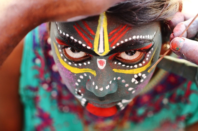 Une jeune fille se maquille pour le festival dédié à Angalamman dans le village tamoul de Kaveripattinam. Ce festival évoque toutes les expressions de la déesse autours du thème de la force féroce. (photo par Raja Subramaniyan pour National Geographic). 