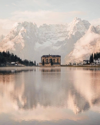 Belle photo : un grand hôtel des Alpes se mire dans un lac