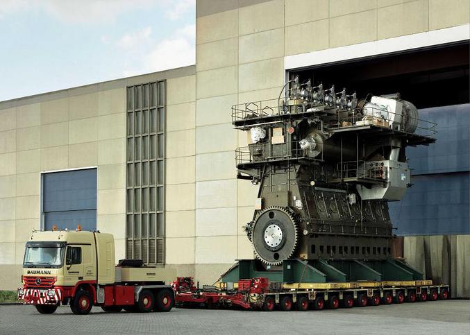 Un énorme moteur de bateau transporté sur un camion.