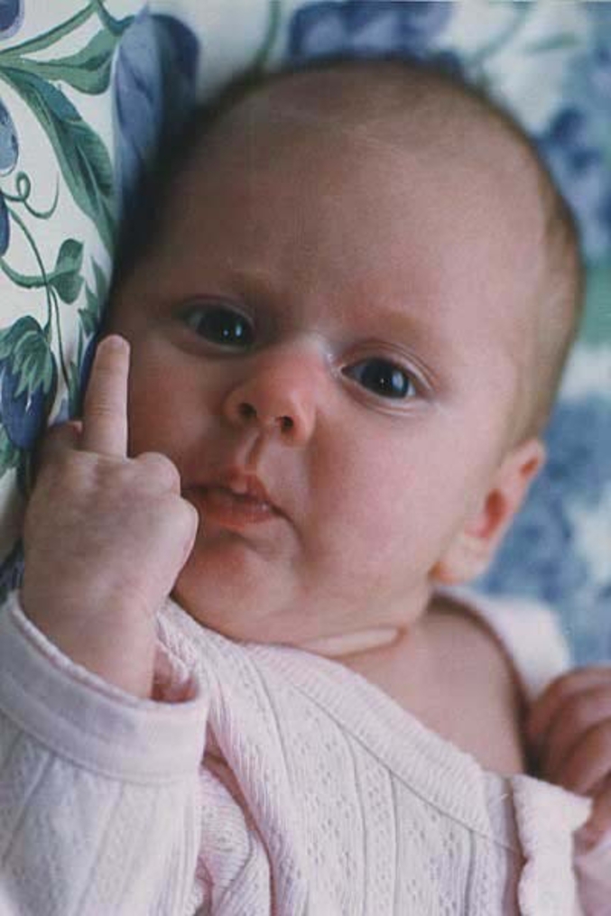 Un bébé fait un doigt d'honneur au photographe