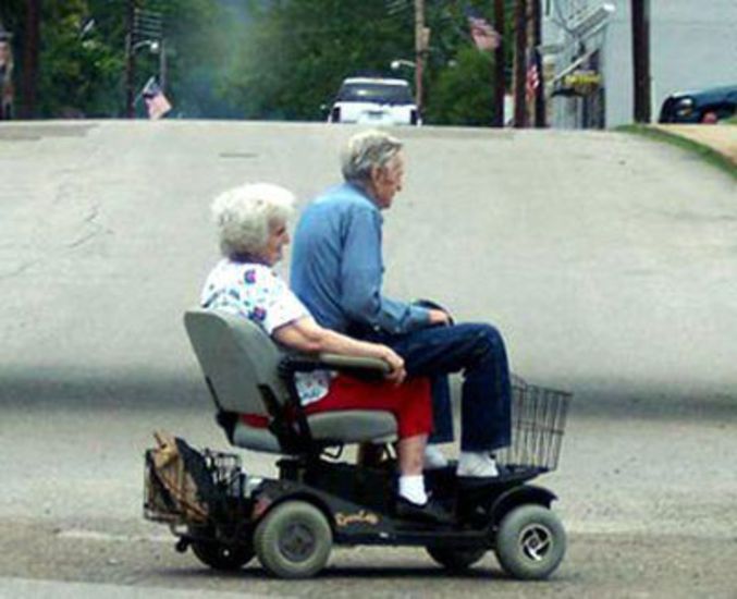 Un couple qui se promène sur un fauteuil roulant électrique