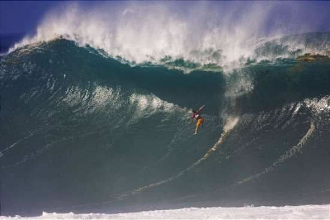 Une vague va engloutir un surfeur.