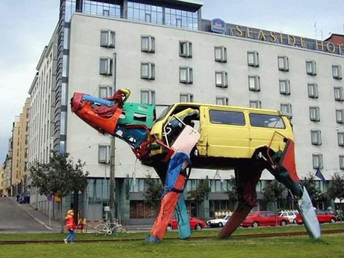 Une statue faire d'épaves de voitures colorées