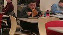 Un asiatique mange une pizza