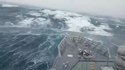 Un bateau face à des vagues énormes et au milieu d'une tempête