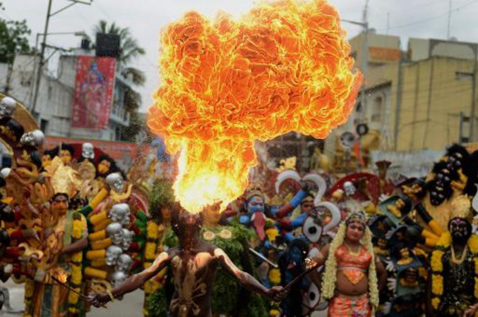Un artiste indien joue avec le feu lors de la procession traditionnelle de Bonalu en hommage à la déesse MahaKali à Hyderabad dans l'Andhra Pradesh (photo AFP).