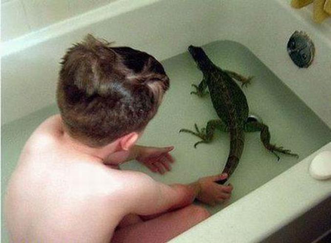 Un enfant qui prend son bain avec un lézard