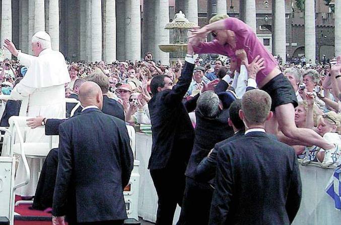 Une femme veut à tout prix s'approcher du Pape.