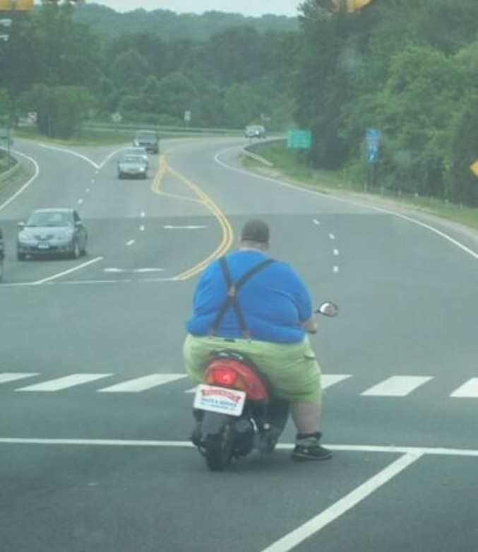 Un homme de forte corpulence sur un scooter.