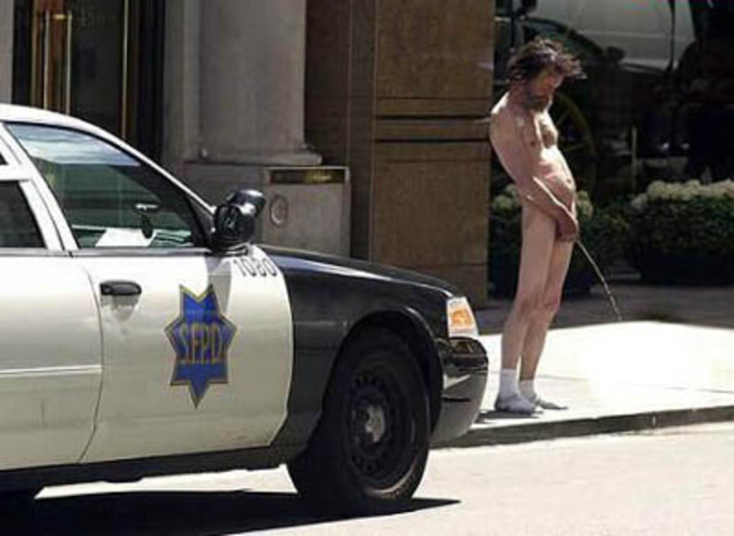 Un homme nu qui urine en pleine rue devant des policiers