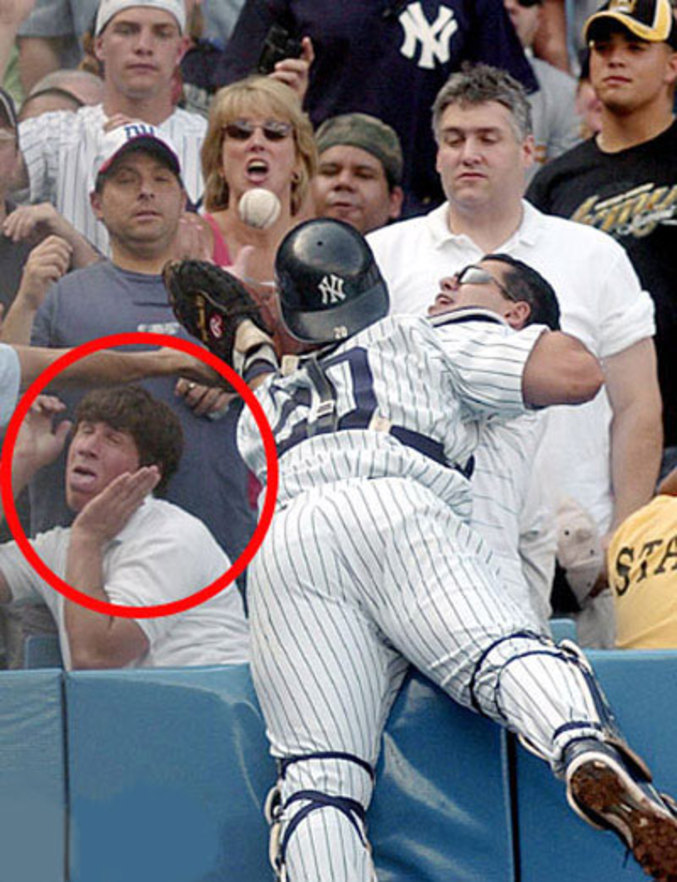 Un spectateur d'un match de Base-ball semble vraiment être anxieux à l'idée d'un choc avec un joueur