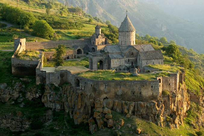 Le monastère a été construit entre les Xe et XIIIe siècles, à l’emplacement d’un sanctuaire ancien. C'était un très grand centre intellectuel de l'Arménie, entre 1390 et 1453, une université reconnue comme celles de Sanahin et de Haghpat. De grands savants théologiens de l’époque ont travaillé dans cette université, comme Grégoire de Tatev. Comme beaucoup de monastères arméniens du Moyen-Âge, Tatev s'est doté d'une muraille contre les invasions de l'époque.

L'origine du nom « Tatev » est mal connue. Selon une légende, l'architecte de Tatev ne pouvait pas descendre de la coupole qui venait alors d'être construite. Il cria alors "Togh astvats indz ta-tev", ce qui signifie « Puisse Dieu me donner des ailes ». Il a en tout cas donné le prénom « Tatev », très utilisé en Arménie.

Source : https://fr.wikipedia.org/wiki/Tatev