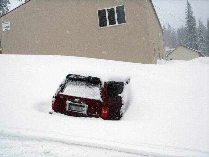 Une voiture entièrement recouverte de neige.