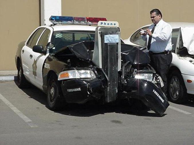 Une voiture de police avec une cabine téléphonique plantée dans le capot.
