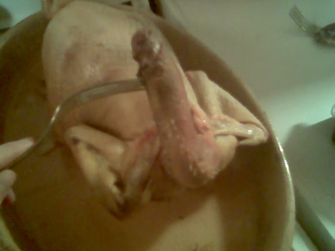 Un poulet prêt à cuire, avec un cou étrange.