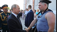 Poutine serre la main à un marin russe à l'uniforme approximatif (pas de vareuse, pas d'insigne...)