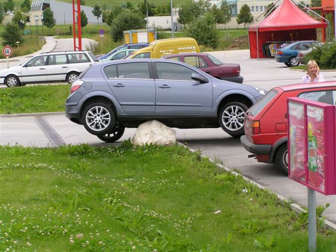 Une voiture est coincée sur une grosse pierre