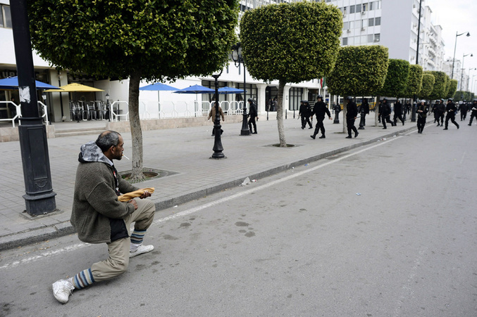 Un manifestant tunisien se tient face aux forces policières au court d'une manifestation contre le nouveau gouvernement tunisien (18 janvier 2011).