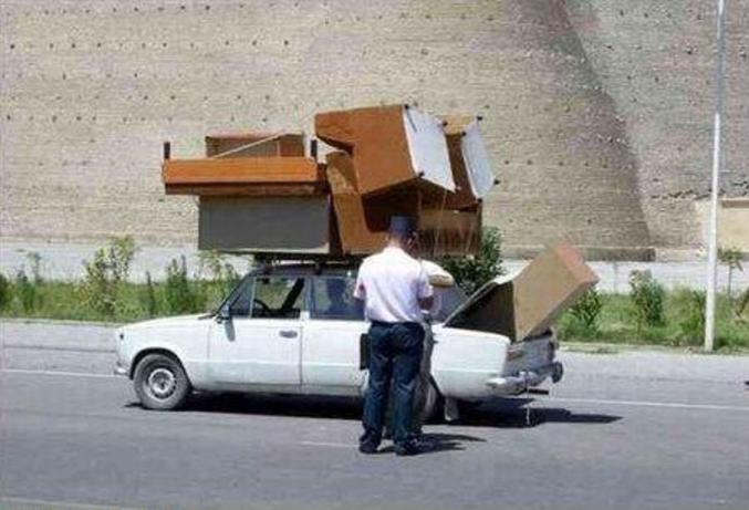 Une voiture qui transporte des meubles sans aucune sécurité.