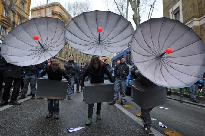 Des manifestants portent des déguisements de paraboles pour protester contre l’installation d’un réseau de satellites de communication développés par le département américain de la Défense américain, en marge de la visite du président Barack Obama à Rome.