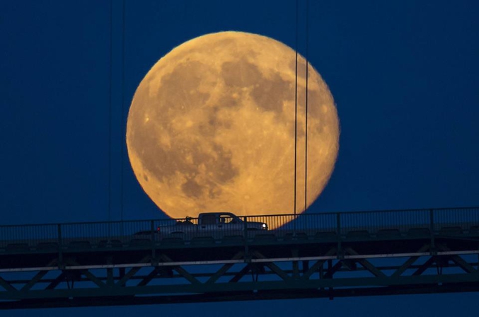 Dans la nuit du 12 au 13 juillet 2014 avait lieu le phénomène dit de Super Lune, c'est à dire une approche maximale du satellite par rapport à la Terre, sa trajectoire de rotation autours de la Terre étant une ellipse décentrée. La Lune semble alors immense et très lumineuse car, lors d’un périgée, elle peut se trouver à environ 50 000 kilomètres plus près de la Terre que lorsqu’elle est à son point le plus loin, l’apogée. Ici, la photo a été prise par John Lehmann au pied du Lions Gate Bridge, à Vancouver (Canada), alors que la Lune était séparée de la Terre par quelques 'petits' 358 257 kilomètres. 2014 est exceptionnelle, les autres super lunes ayant lieu le 10 août (la plus importante, la Lune s'étant rapprochée d'environ 1400 km en plus par rapport à hier) et le 9 septembre prochains.