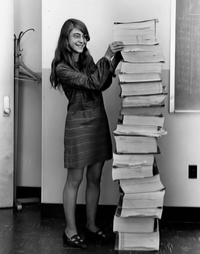Margaret Hamilton, ingénieur logiciel sur le projet Apollo posant avec son code source