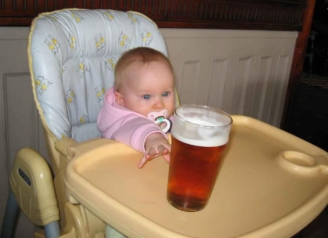 Un bébé se jette sur une pinte de bière.