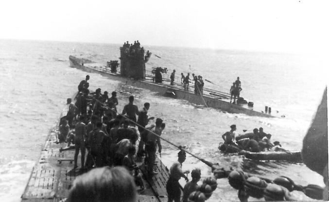 Les U156 et U507 sauvant les survivants du RMS Laconia, que l’U156 a torpillé. C’est devenu un tournant dans la guerre. Jusque-là, il était courant pour les équipages de sous-marins allemands d’aider les survivants des navires qu’ils avaient coulés. Ils leur donnaient de la nourriture, de l’eau et des indications pour débarquer, ou parfois les emmenaient comme prisonniers de guerre sur leur propre bateau. Dans ce cas, ils remorquaient des canots de sauvetage remplis de personnel allié et de prisonniers de guerre italiens, avec beaucoup d’autres sur les ponts des sous-marins eux-mêmes. Ils diffusent leur position et leurs intentions à tous ceux qui se trouvent à portée. Néanmoins, un bombardier américain les a repérés et a reçu l’ordre d’attaquer, tuant de nombreux survivants avec leurs canons et leurs bombes, et beaucoup plus lorsque les sous-marins ont été forcés de plonger en catastrophe pour éviter d’être coulés. En réponse, le chef de la marine allemande, Donitz, a donné l’ordre de cesser d’aider les survivants. Seuls les capitaines et les ingénieurs en chef devaient être pris comme prisonniers de guerre, s’ils pouvaient le faire en toute sécurité. Lors de son procès à Nuremberg, Donitz a été accusé de cela, mais s’est défendu avec succès en soulignant qu’il s’agissait d’une réponse aux crimes de guerre des Alliés, et que les Alliés avaient eux-mêmes une politique similaire en ce qui concerne les survivants des sous-marins allemands et de la flotte de surface allemande.