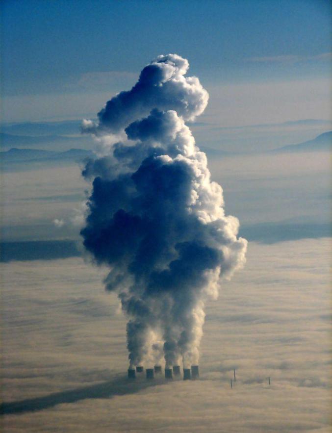 Les cheminées d'une usine qui passent au-dessus des nuages.