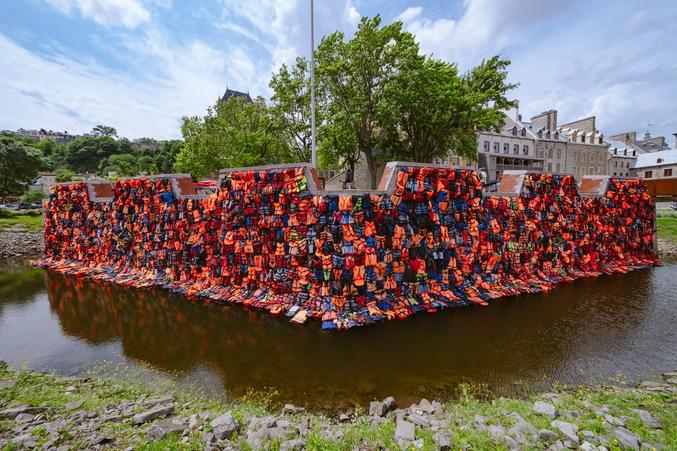 Ai Weiwei a conçu le mur de gilets de sauvetage pour représenter les frontières physiques et administratives qui se dressent sur le chemin des réfugiés alors qu'ils tentent de fuir la guerre civile en cours en Syrie dans l'espoir de trouver la sécurité en Europe (remparts historique de la ville de Québec )