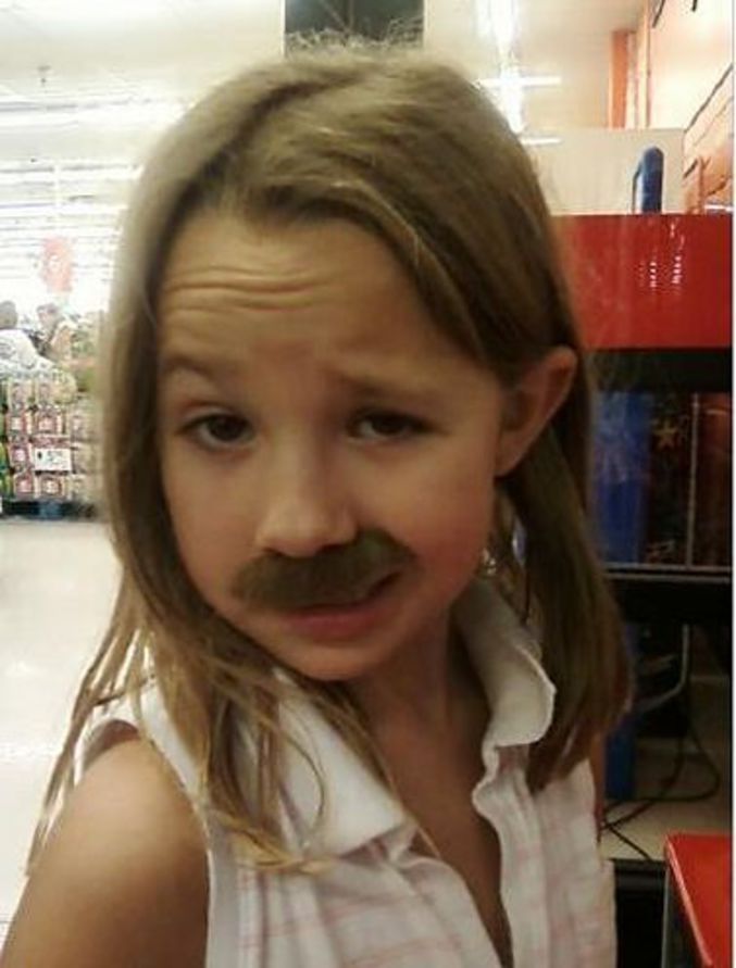 Une petite fille avec une moustache.