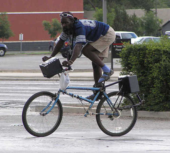 Un cycliste qui a une posture inhabituelle