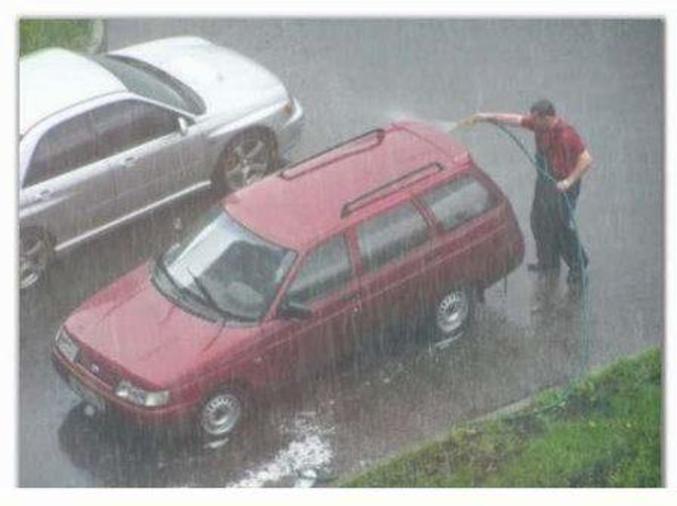 Un homme lave sa voiture sous la pluie ...