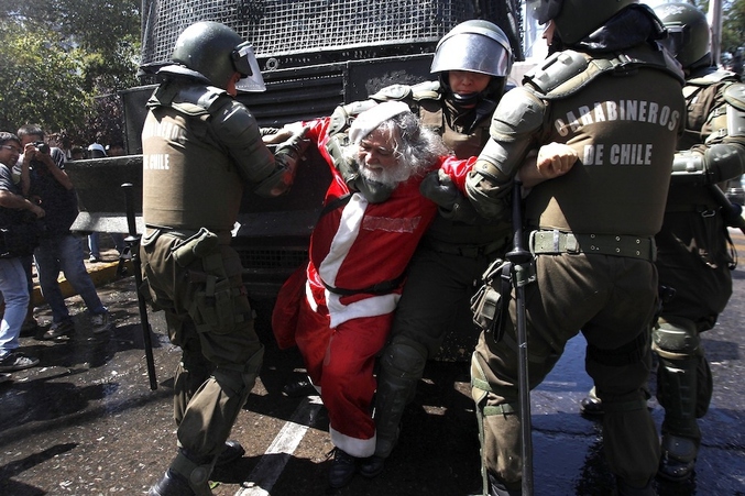 Le 22 décembre, un manifestant Chilien déguisé en père noël se fait arrêter alors qu'il manifeste contre les réformes de l’éducation.