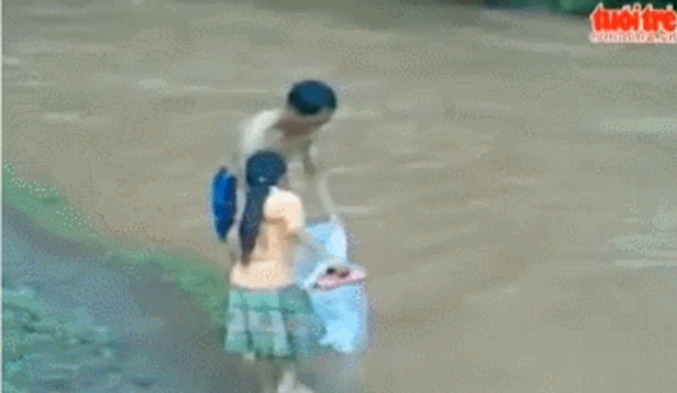 Un père met sa fille dans un sac étanche pour traverser une rivière