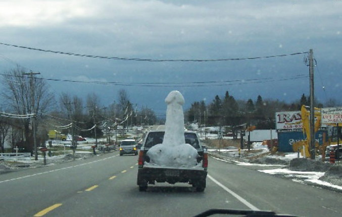 Un sexe en neige à l'arrière d'un pick-up sur la route.
