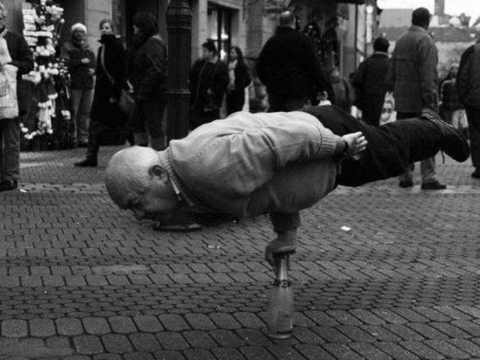 Un grand-père tient en équilibre sur un bras sur une bouteille.