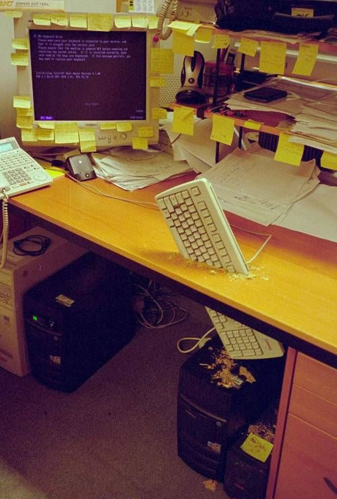 Un clavier enfoncé dans un bureau par une personne enervée