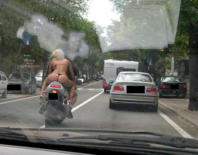 Une jeune femme passagère sur une moto dénudée