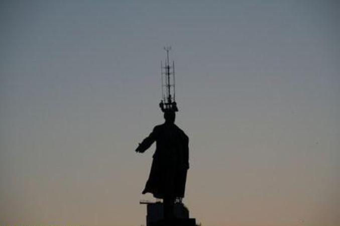 Une illusion avec une antenne radio et une statue.